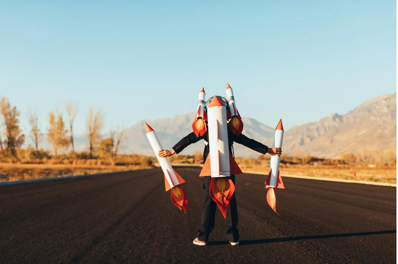 Niño de traje con cohetes de juguete, listo para el lanzamiento. Inversión emprendedora.