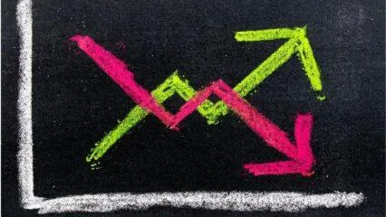 Gráfico de líneas con flechas que indican tendencias opuestas en el mercado de valores. Influencia en el precio de las acciones.