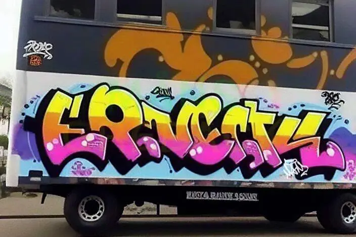 Arte de grafiti vibrante en el costado de un camión, con la palabra 