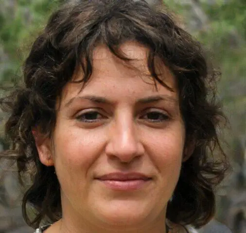 Retrato en primer plano de una mujer con cabello castaño corto y rizado.