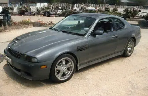 Un cupé Acura Legend gris estacionado en un estacionamiento