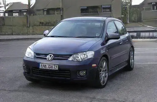 Volkswagen azul de modelo compacto estacionado en la calle, con llantas deportivas y detalles modernos. Ideal para entusiastas de los automóviles y la cultura automovilística.