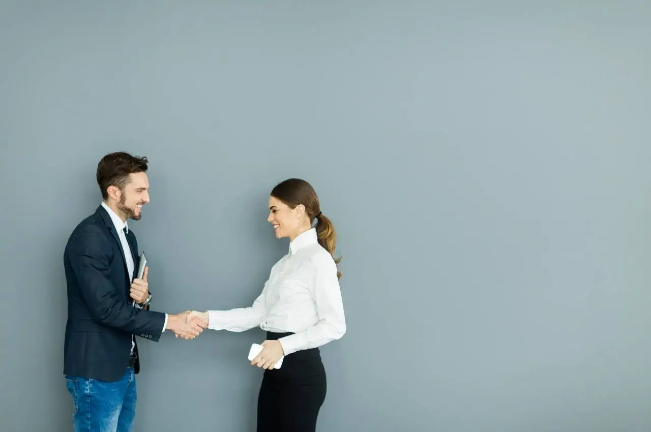 Hombre de negocios y mujer de negocios se dan la mano, lo que significa un acuerdo o asociación exitosa.