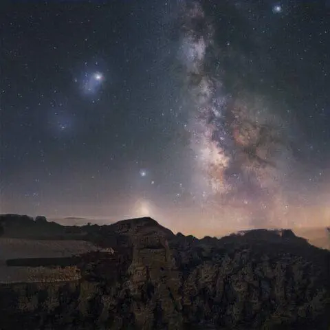 La Vía Láctea se eleva sobre un paisaje rocoso por la noche.