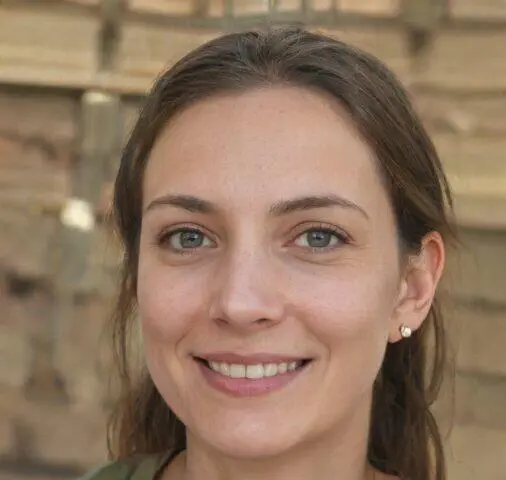 Mujer sonriente con cabello castaño claro y ojos azules, en un entorno natural con fondo desenfocado.
