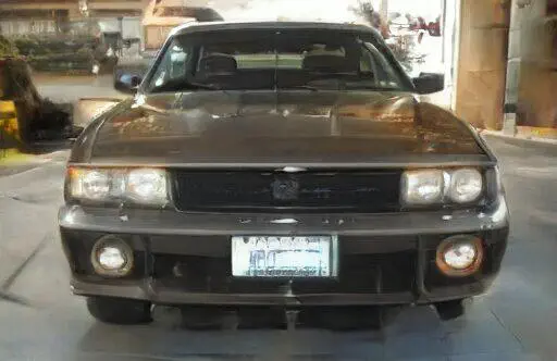 Vista frontal de un Mitsubishi GTO gris oscuro personalizado.